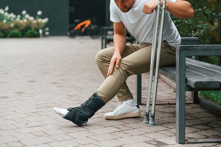 touching-the-leg-man-with-crutches-minimum-invasive-surgery
